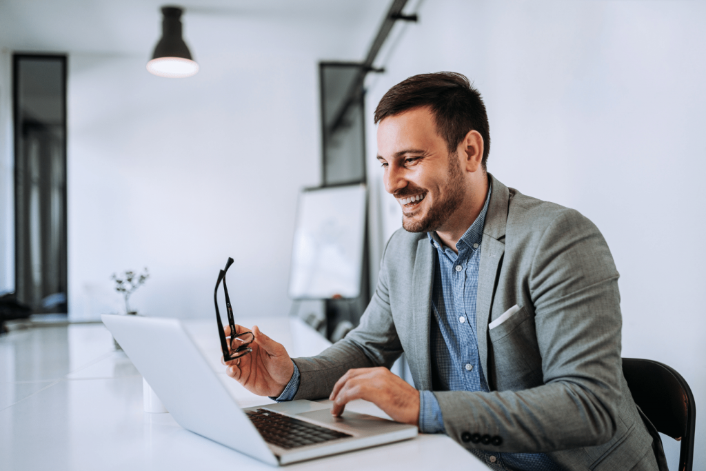 happy businessman working on laptop using writesonic